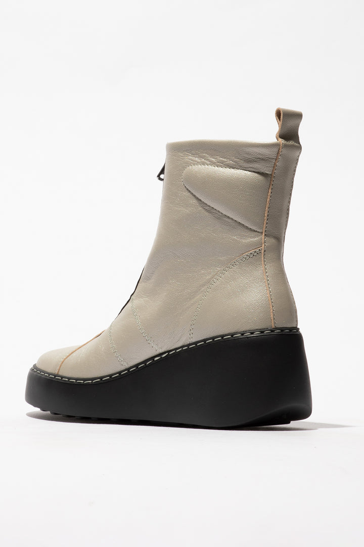 Beige ankle boot with black sole on a white background