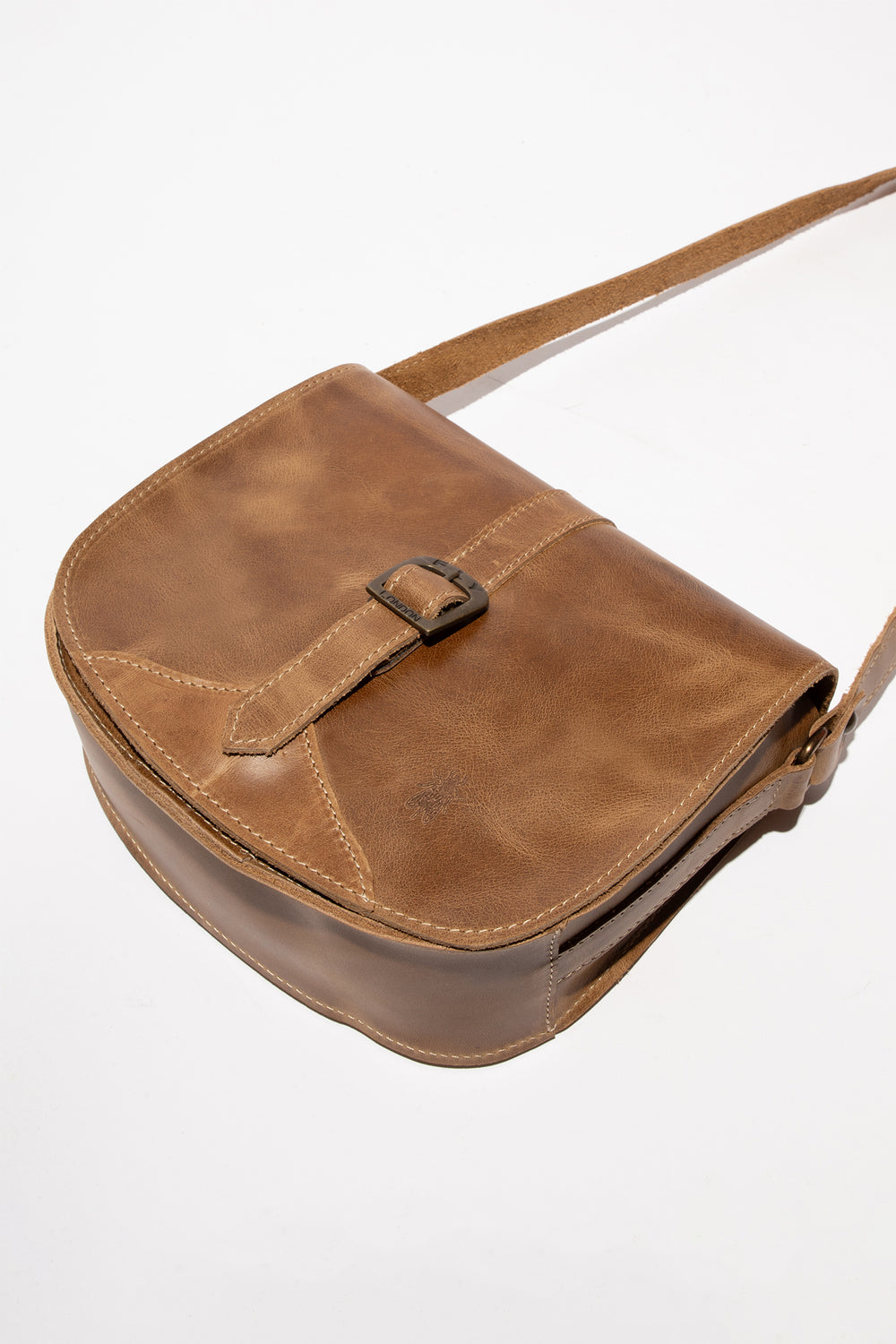 Brown leather bag with a strap on a white background