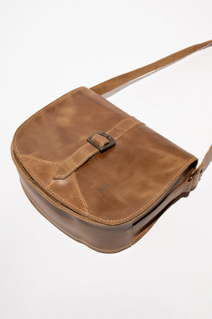 Brown leather bag with a strap on a white background