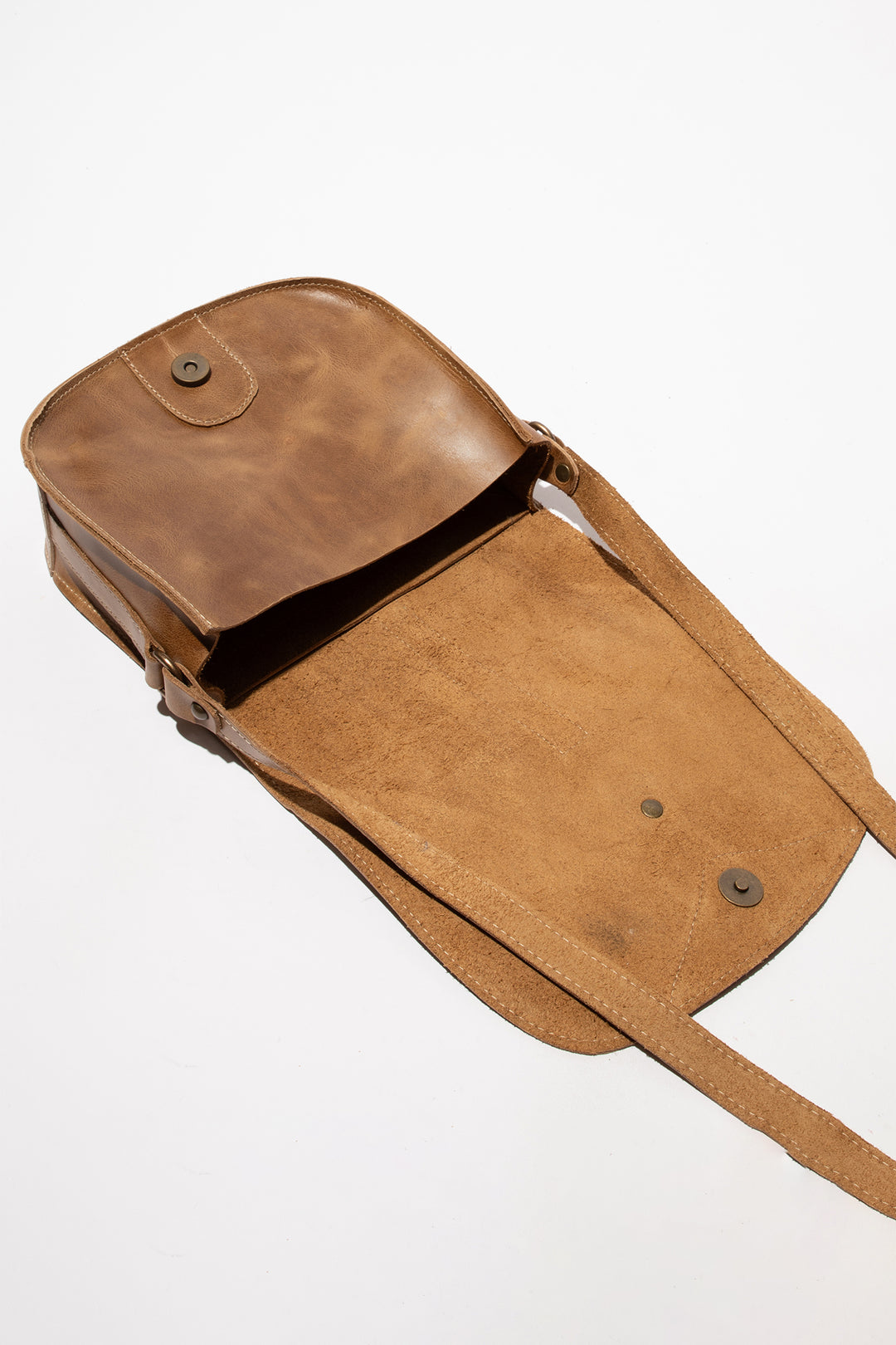 Brown leather bag with a strap on a white background