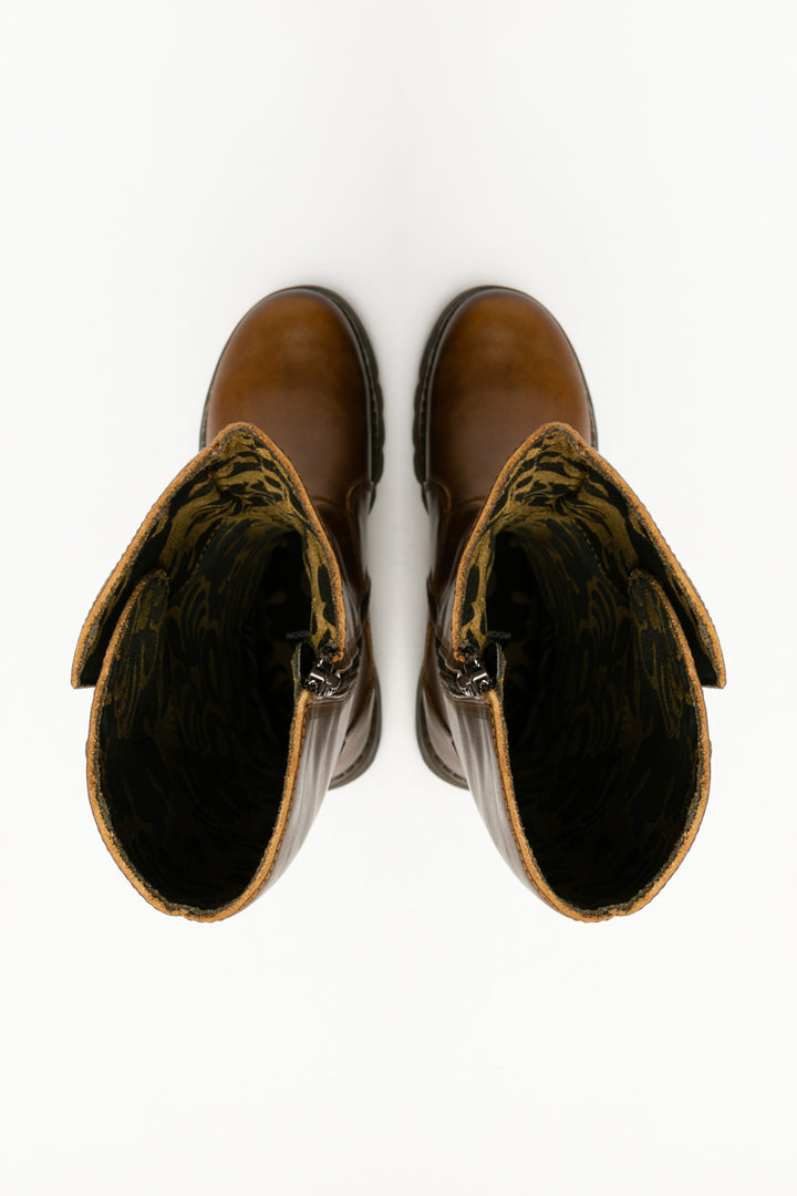 Pair of brown leather boots with decorative bows on a white background