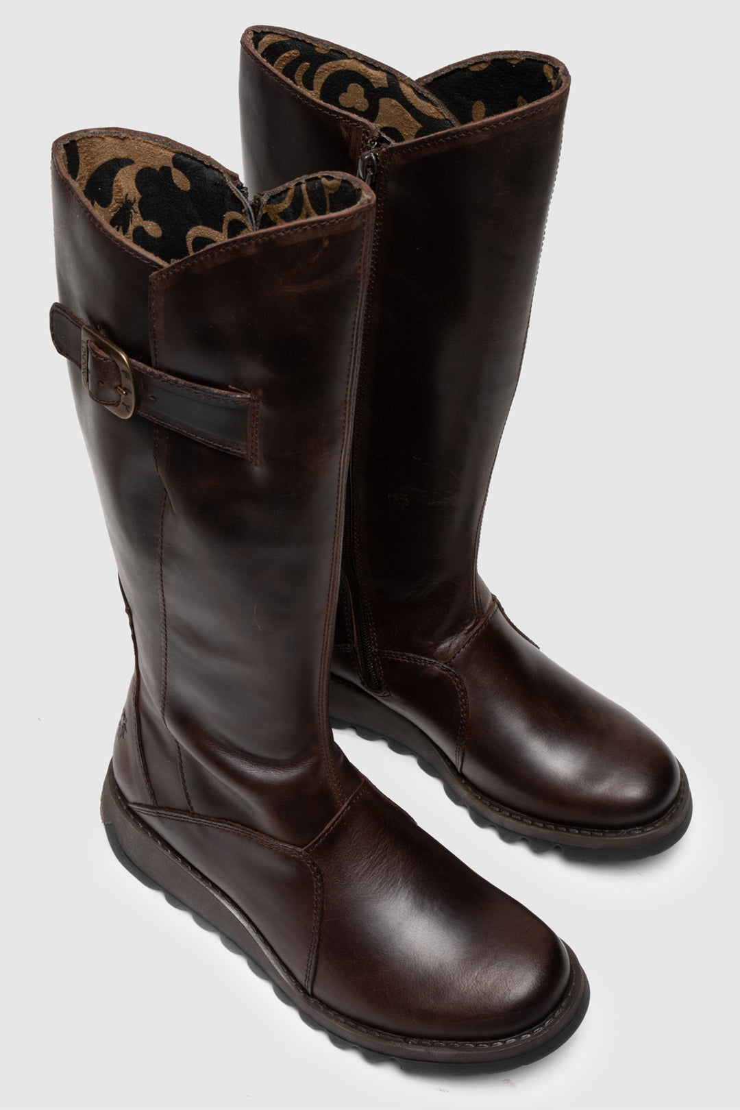 Pair of brown leather boots with a buckle on a light gray background