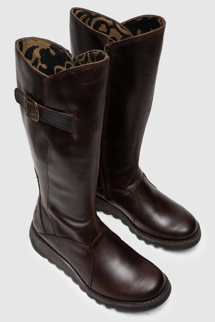 Pair of brown leather boots with a buckle on a light gray background