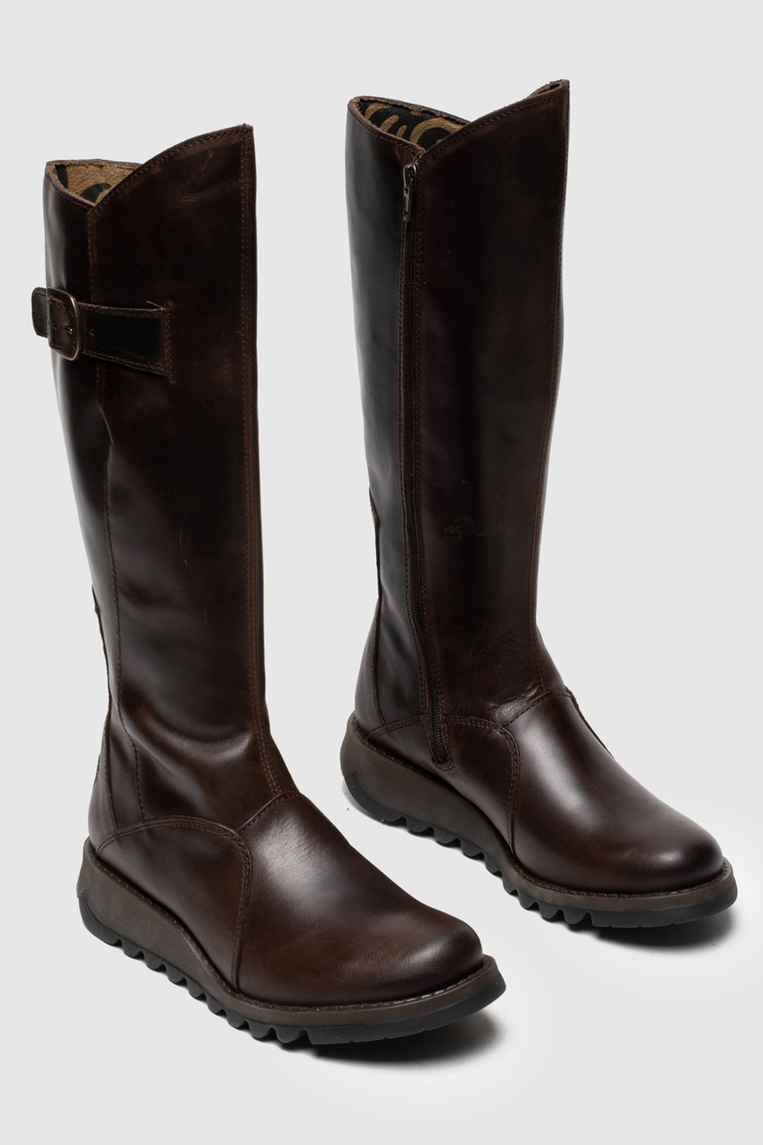 Pair of brown knee-high boots on a light gray background