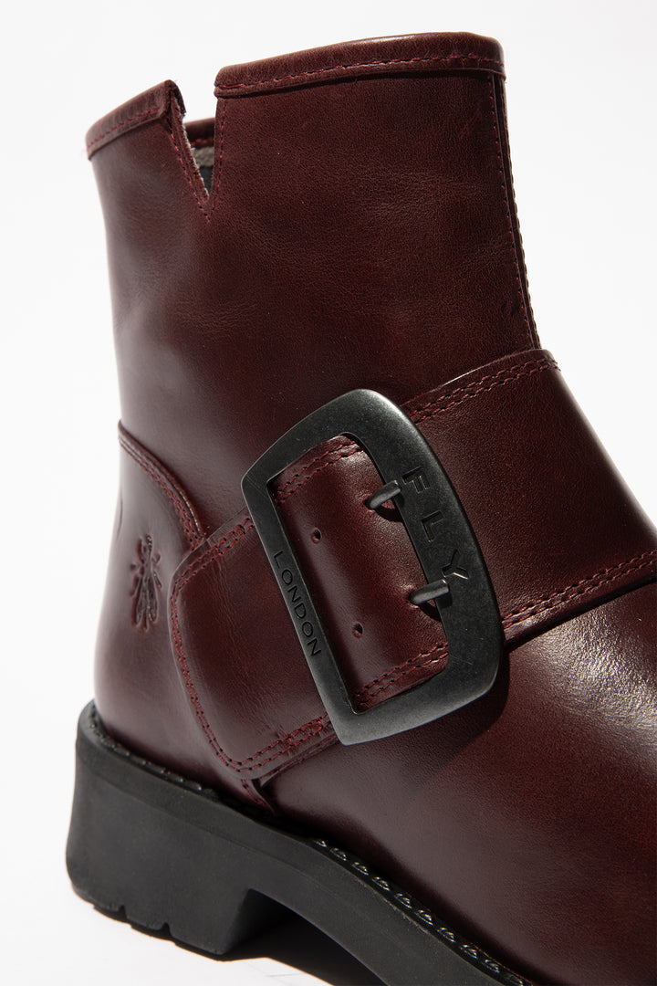 Brown leather boot with a buckle on a white background