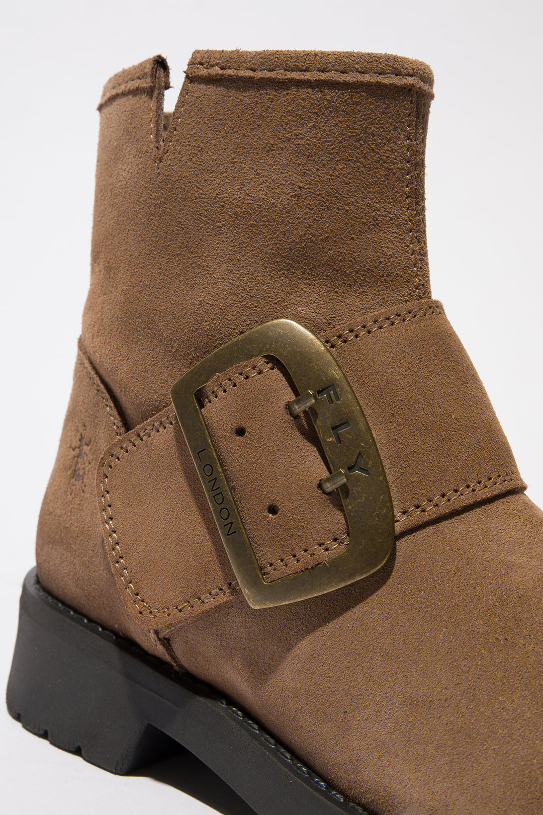 Brown suede boot with a buckle on a white background