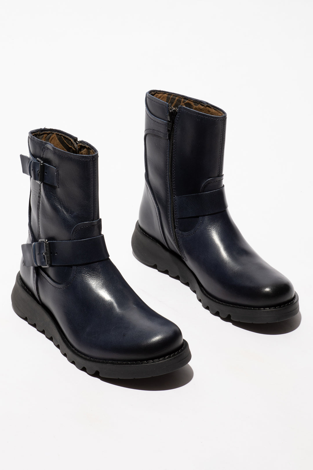 Pair of navy leather boots with buckles on a white background
