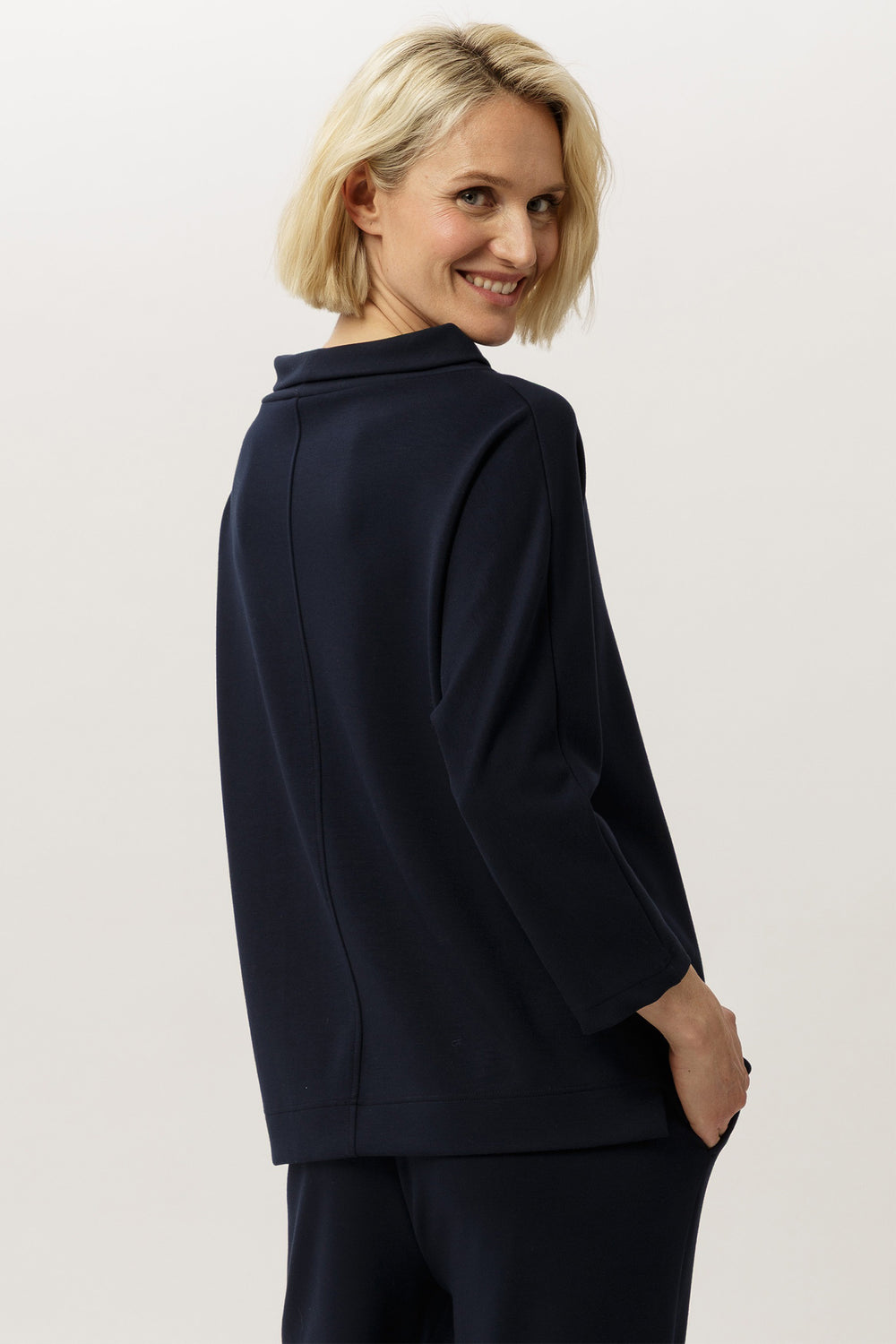 Woman wearing a navy blazer against a plain background