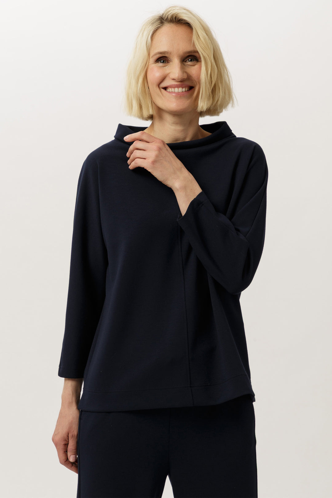 Woman wearing a black long-sleeve top against a white background
