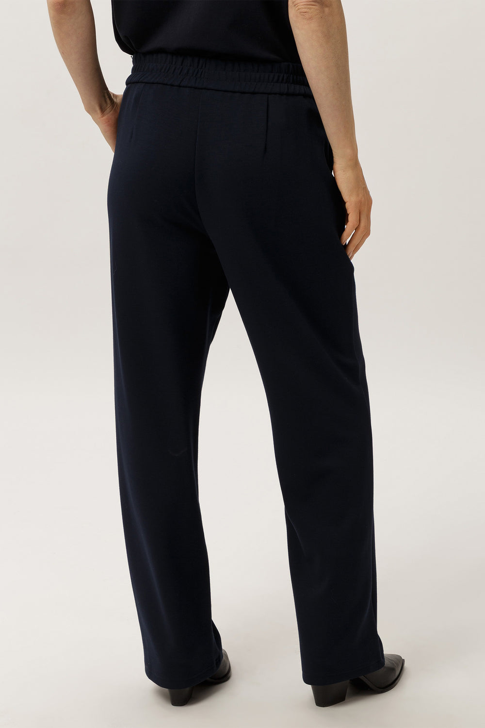 Person wearing navy pants on a white background
