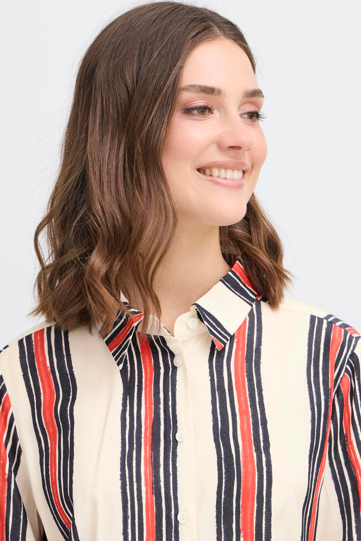 Woman wearing a striped shirt with a plain background