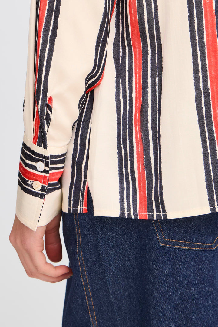 Close-up of a person wearing a striped shirt with red, blue, and white horizontal lines.