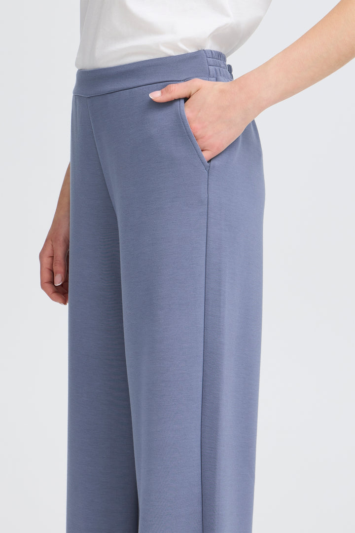 Blue pants worn by a person on a white background