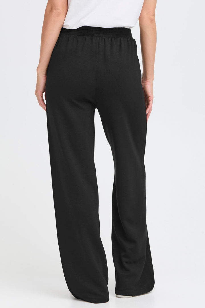 Black wide-leg pants worn by a person on a white background