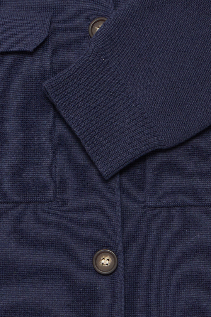 Close-up of a navy blue textured fabric with buttons on a matching background