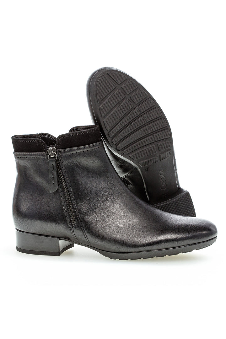 Black leather ankle boots with a zipper on a white background