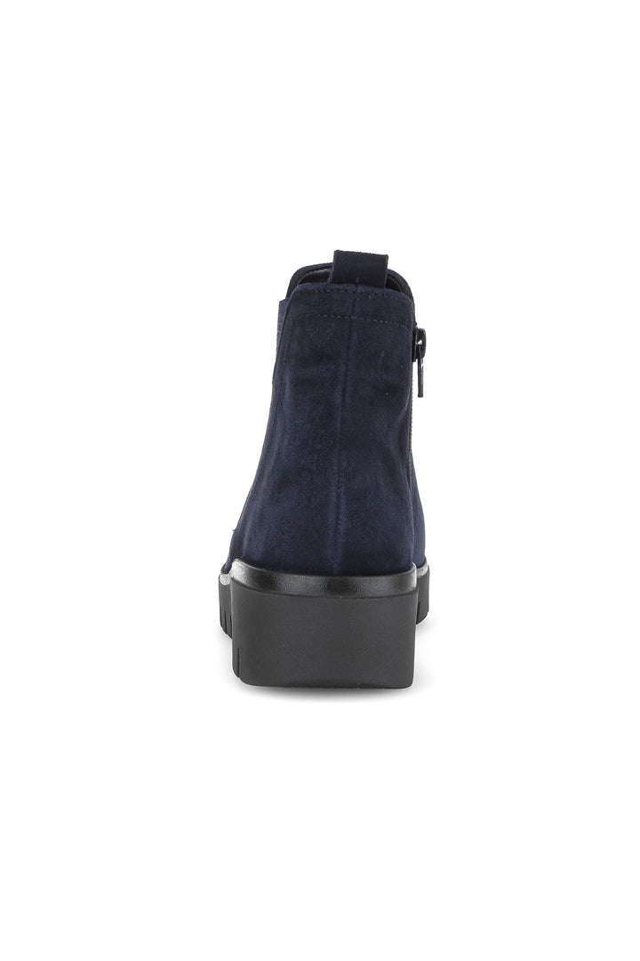 Navy blue suede ankle boot with a black platform sole on a white background