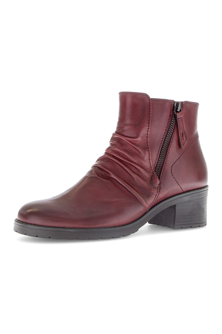 Burgundy ankle boot with a zipper on a white background