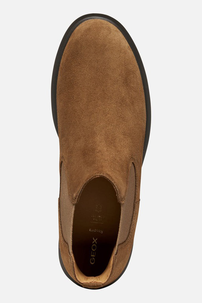 Brown suede slip-on shoe with black sole on a white background