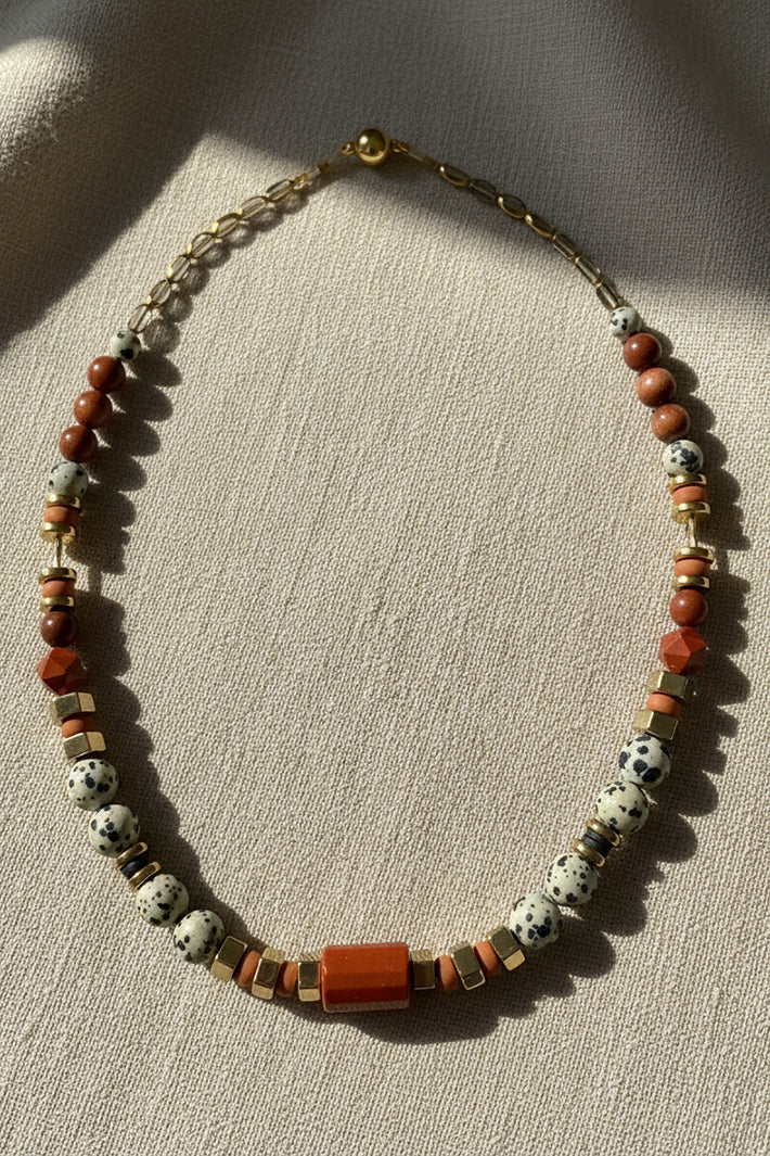 Gist Jewellery Red and Cream Dalmatian Jasper and Sandstone Barrel Necklace BDL02, laid flat in warm light