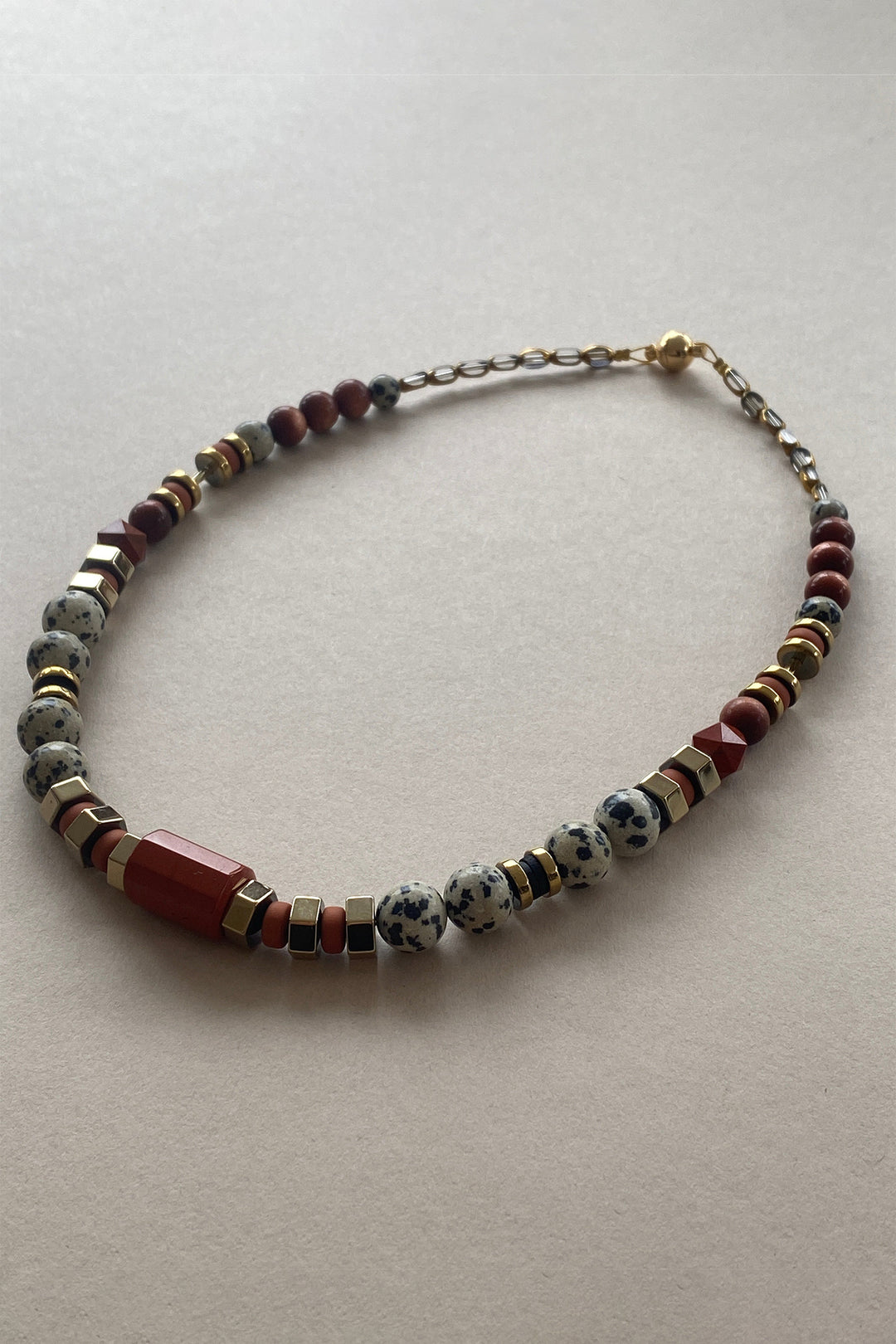 Gist Jewellery Red and Cream Dalmatian Jasper and Sandstone Barrel Necklace BDL02, laid flat, side angle