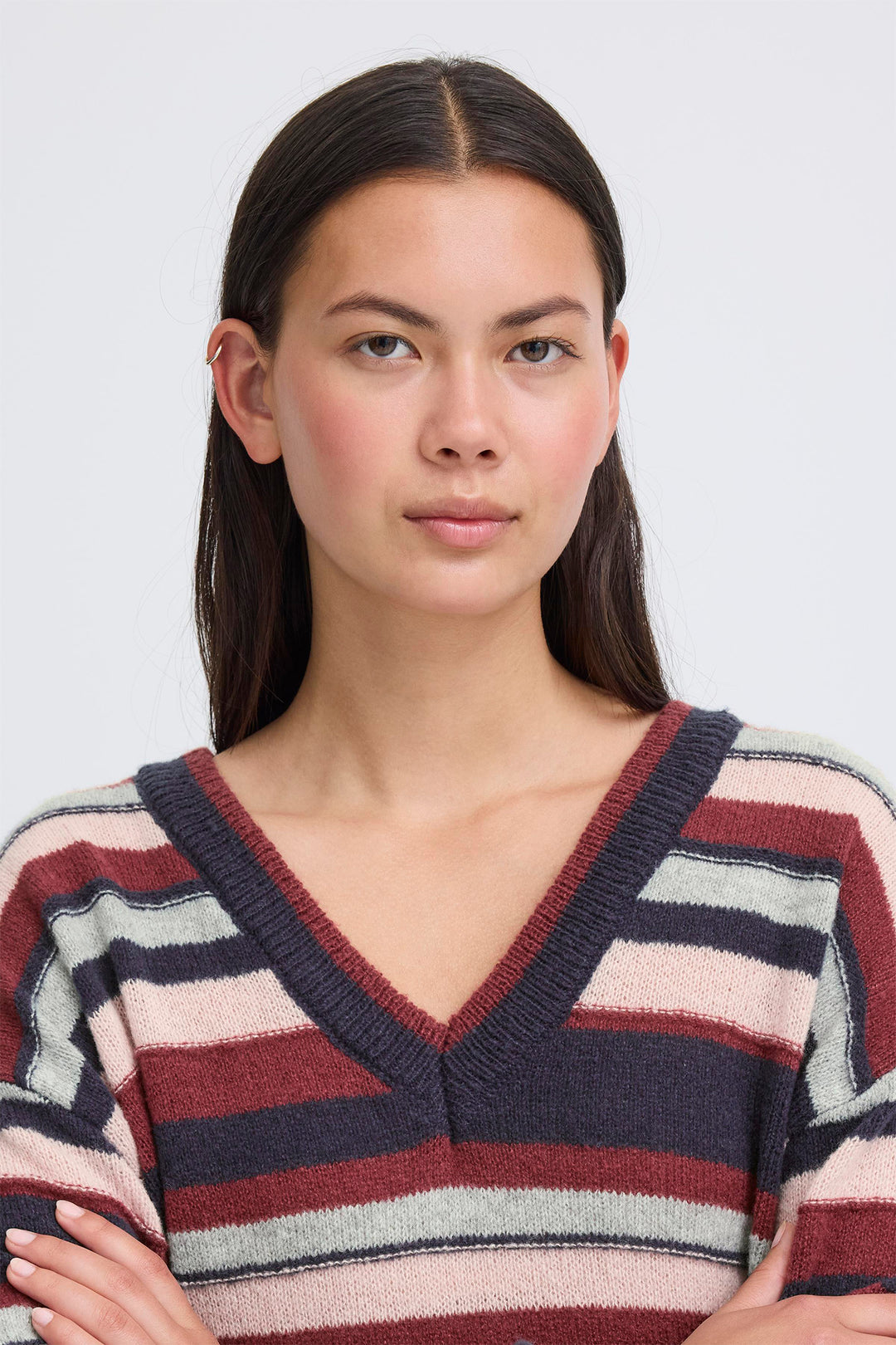 Woman wearing a striped sweater against a plain background