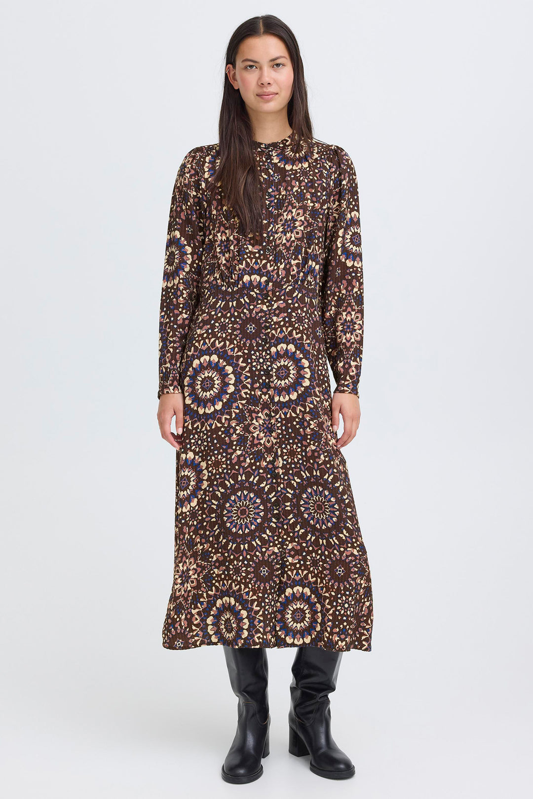 Woman wearing a long, patterned dress on a white background