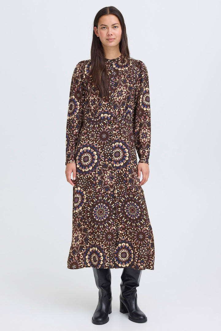 Woman wearing a long, patterned dress on a white background