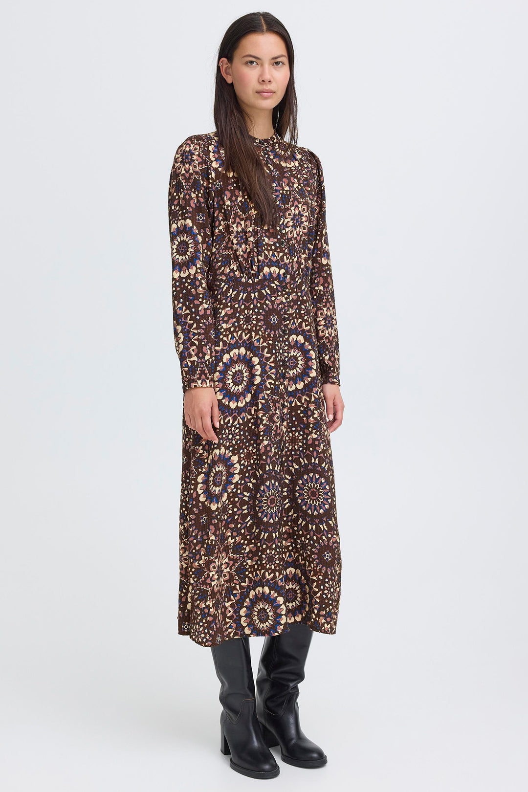 Woman wearing a long, patterned dress on a white background