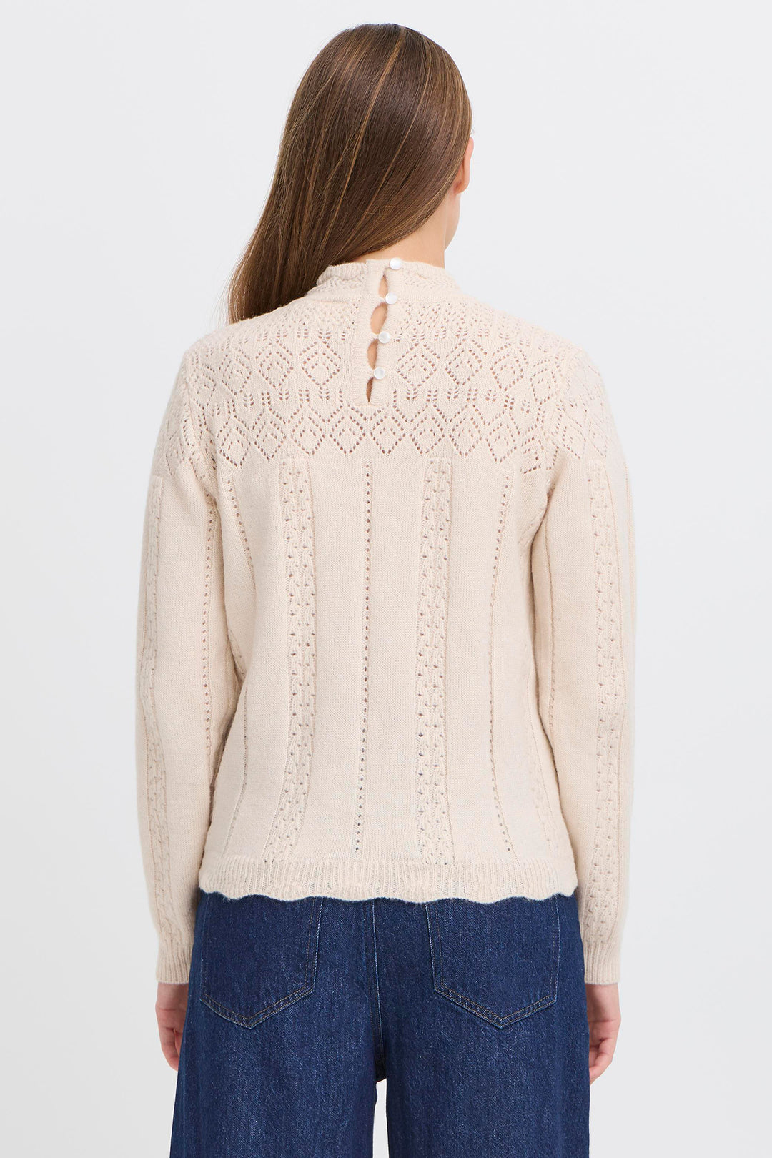 Woman wearing a beige knitted cardigan with a white background