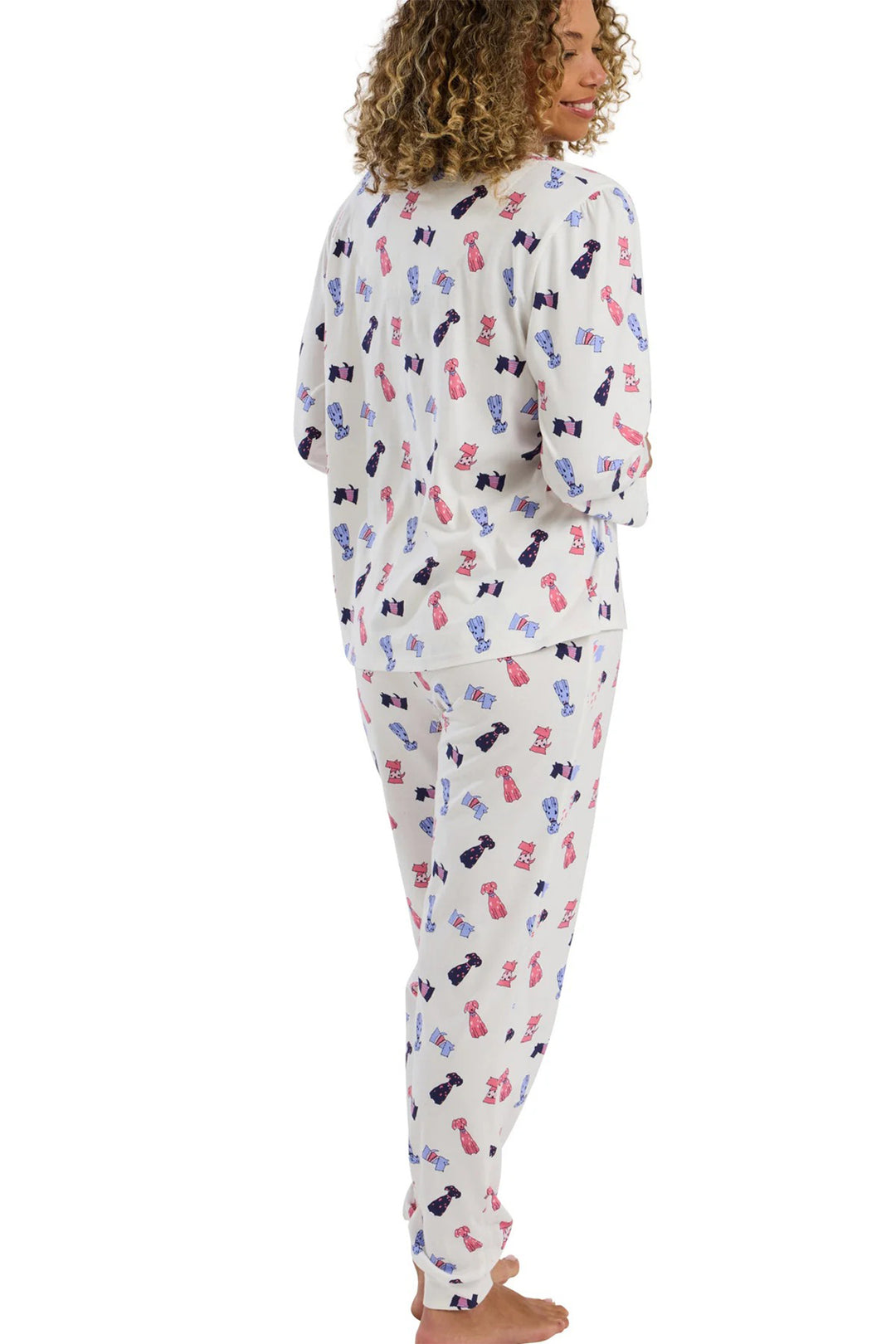 Woman wearing a pajama set with colorful bow pattern on a white background