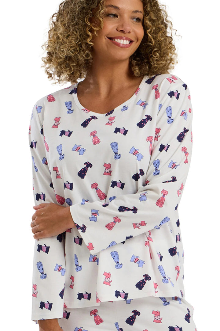 Woman wearing a long-sleeve top with colorful dog pattern on a white background