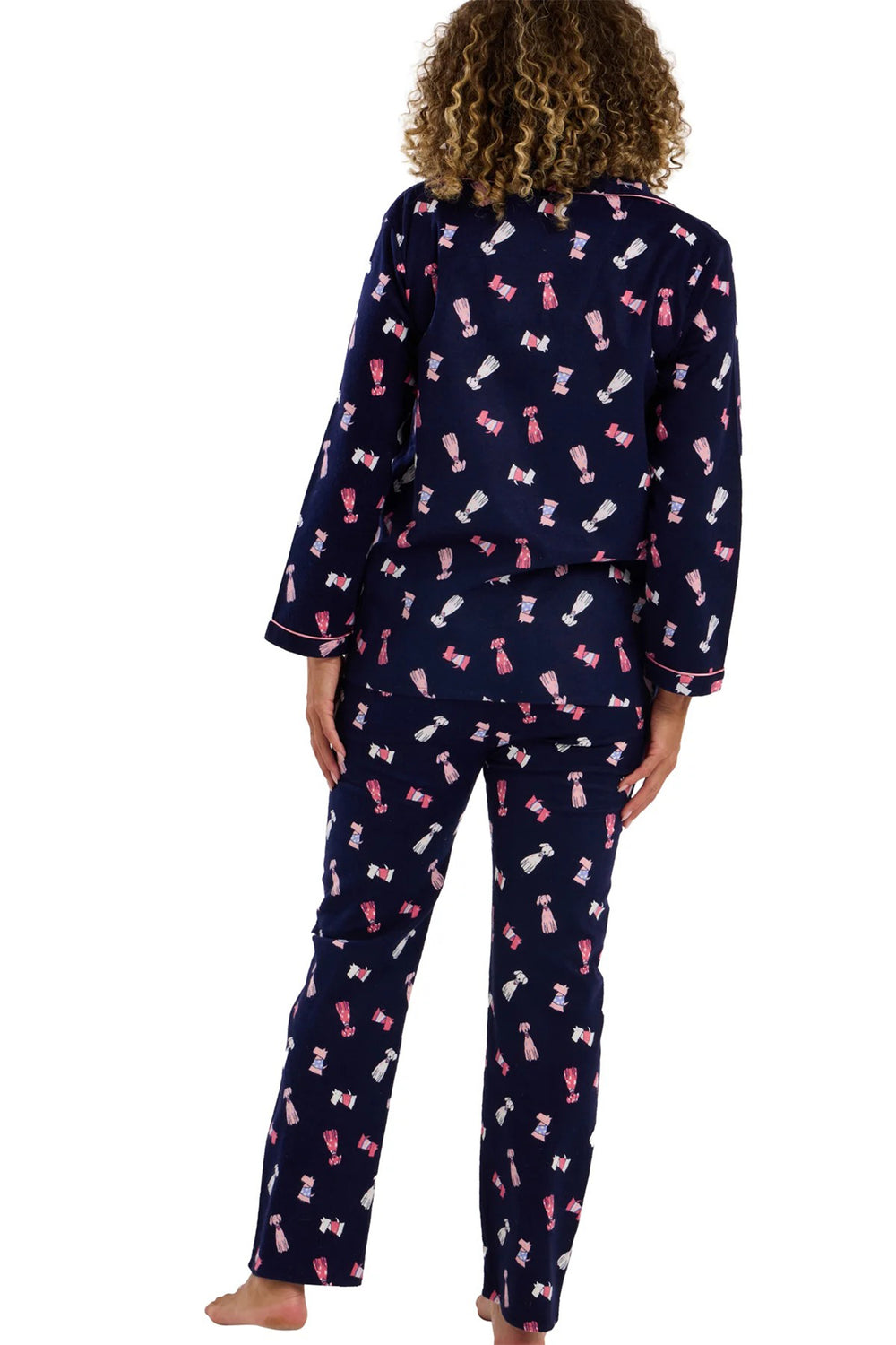 Navy blue pajama set with pink bow pattern worn by a person on a white background