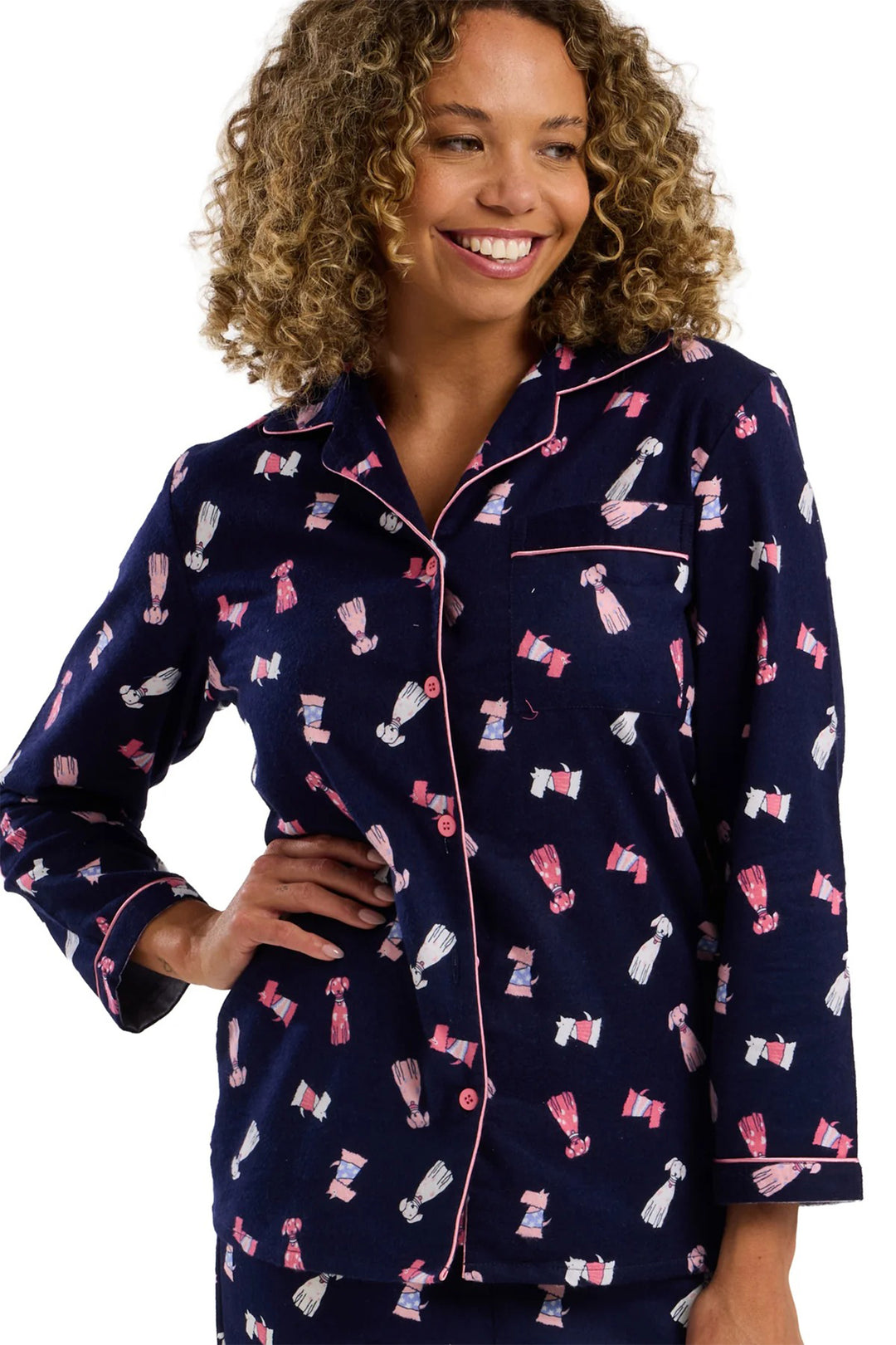 Woman wearing navy pajamas with pink and white patterns on a white background