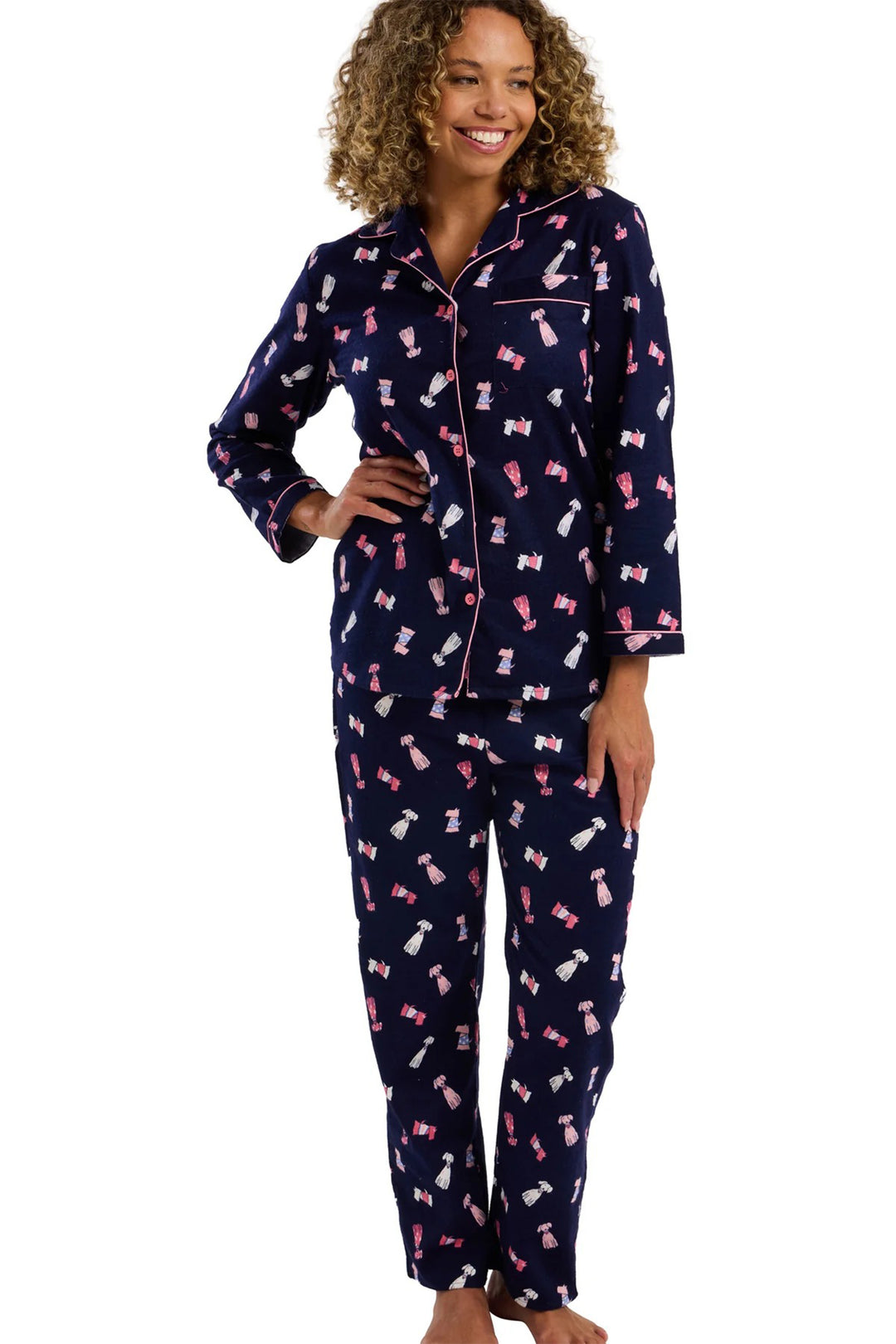 Woman wearing navy blue pajamas with pink bows on a white background