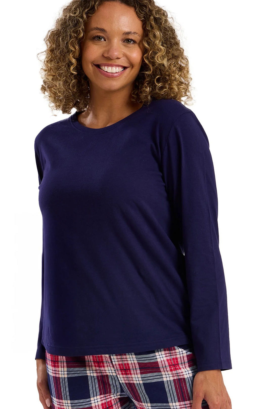Woman wearing a navy long-sleeve top and plaid pants on a white background