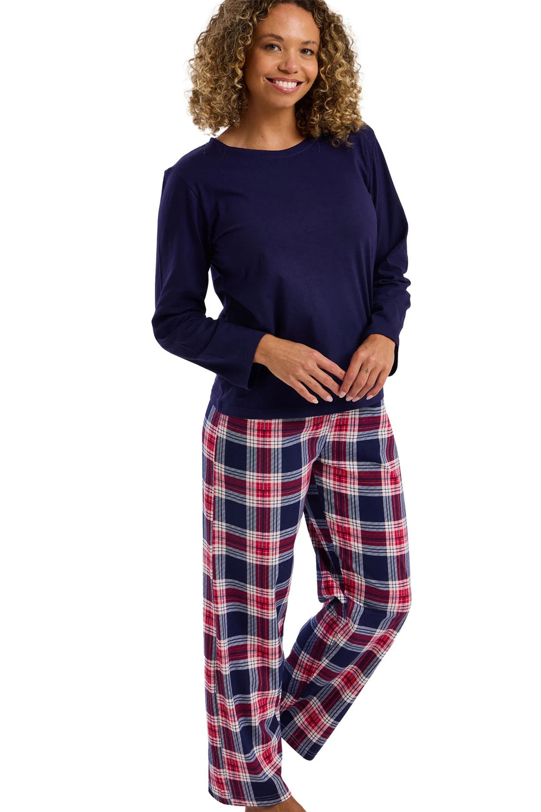 Woman wearing a navy long-sleeve top and plaid pants on a white background