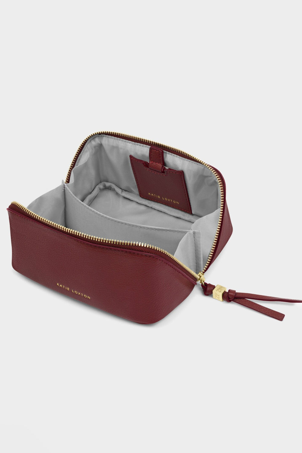 Maroon leather pouch with gold zipper on a light gray background