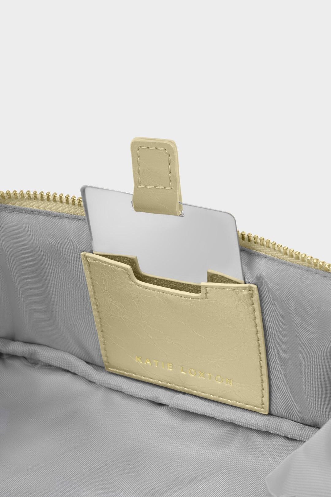 Gray bag with beige card holder and 'Baptiste' branding on a light gray background