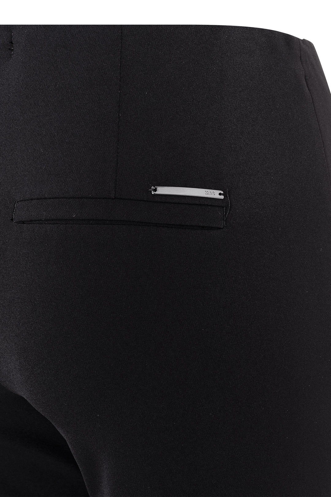 Close-up of a black pocket with a small metallic tag on a black background