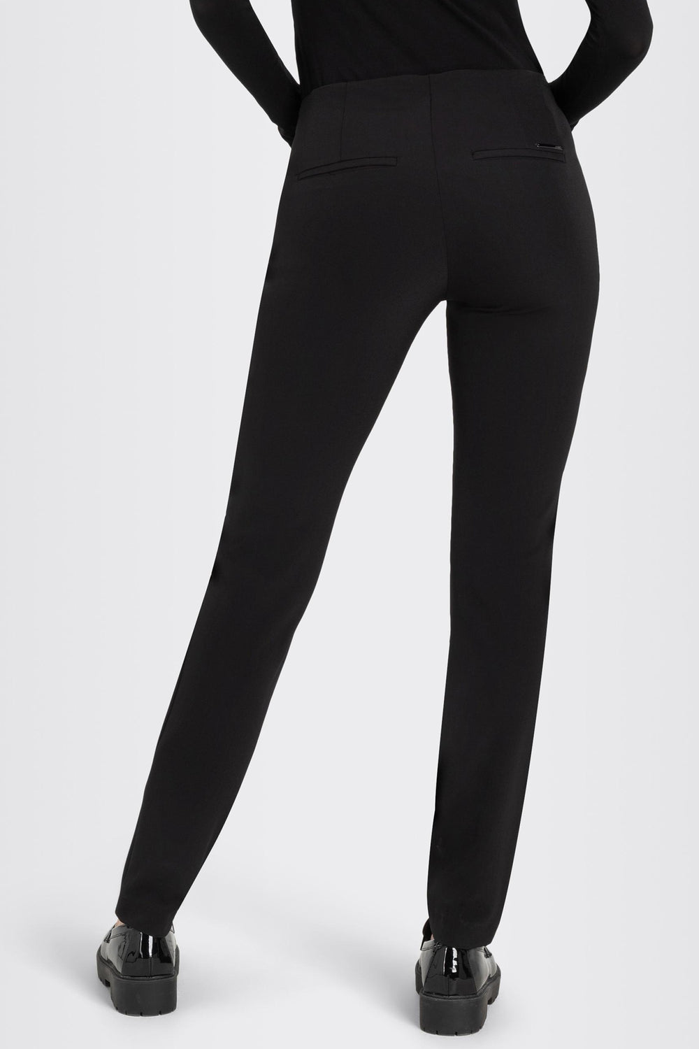 Black pants worn by a person on a white background