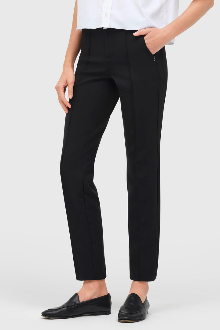 Person wearing black pants and a white shirt on a plain background