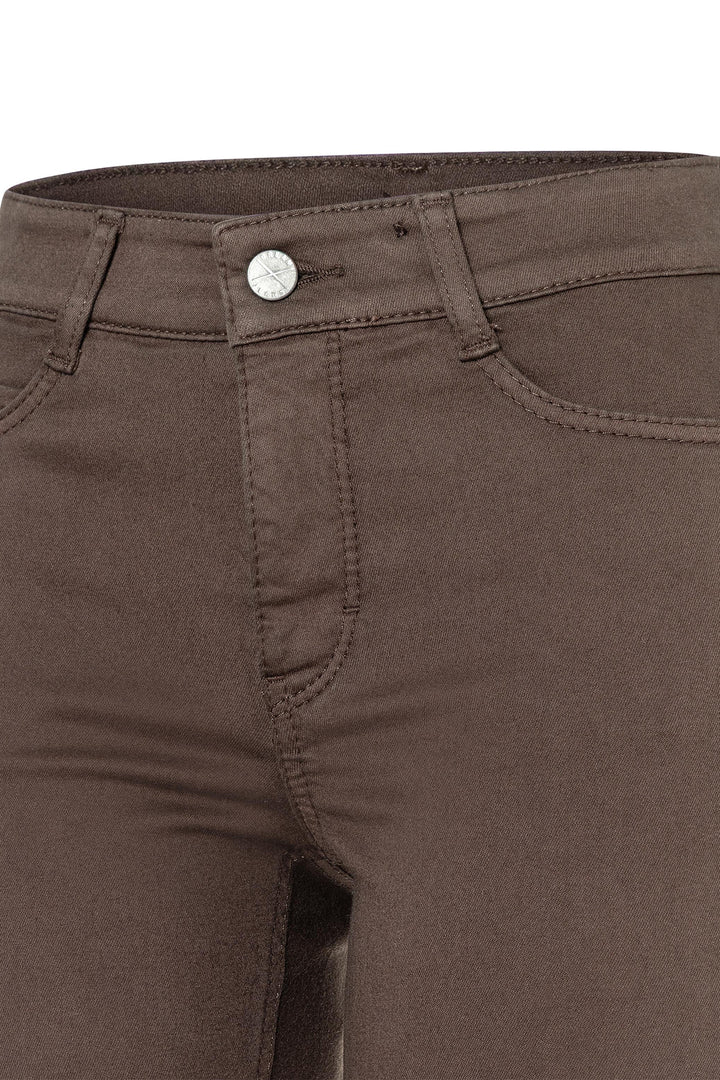 Close-up of brown pants with a button detail on a white background