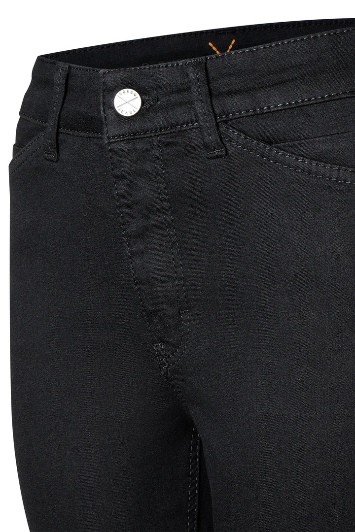 Close-up of black pants with a button detail on a white background