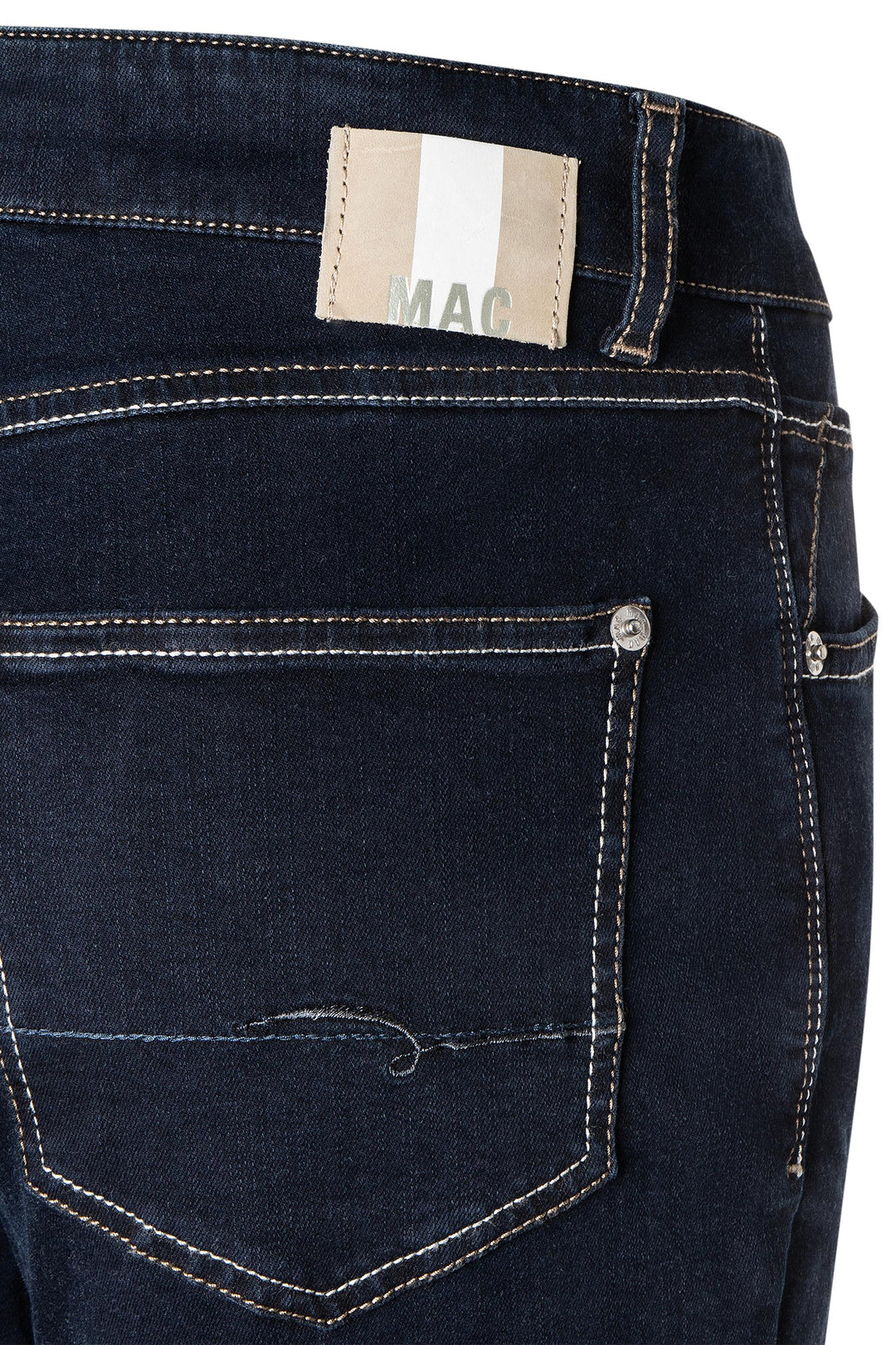 Close-up of dark blue jeans with a brand label on a white background