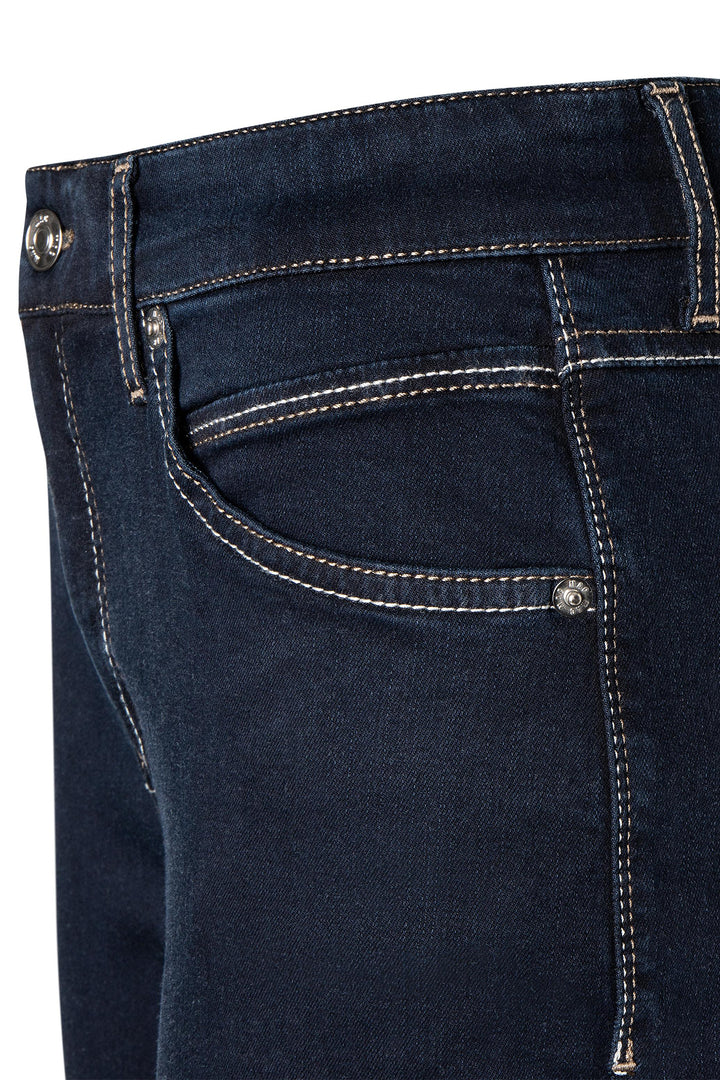 Close-up of dark blue jeans with stitching details on a white background