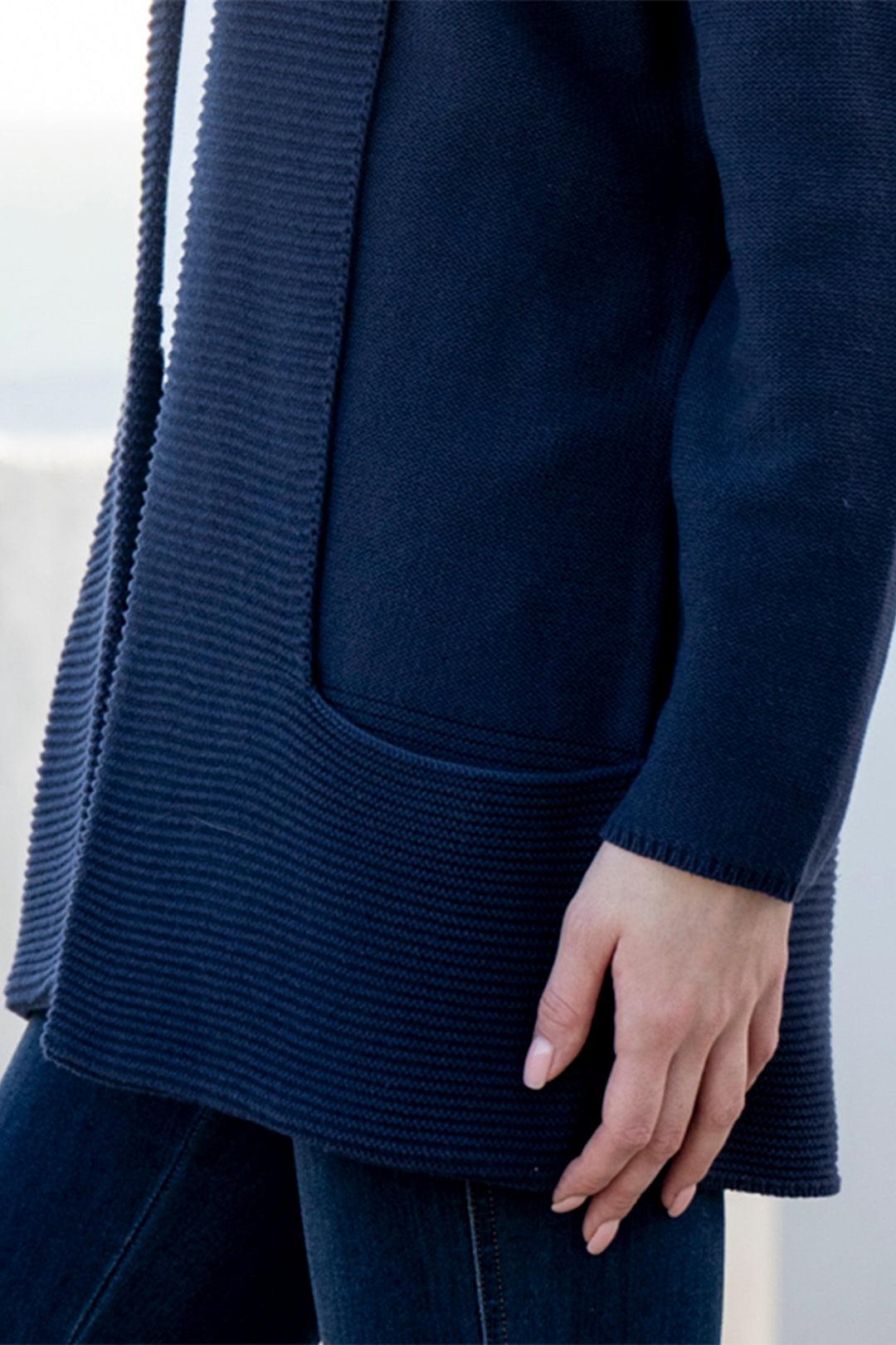 Navy blue cardigan worn by a person on a light background