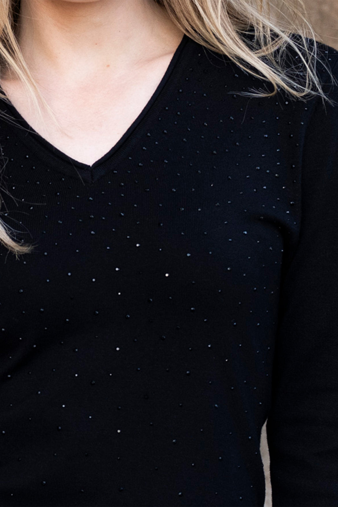 Black long-sleeve top with small white dots worn by a person
