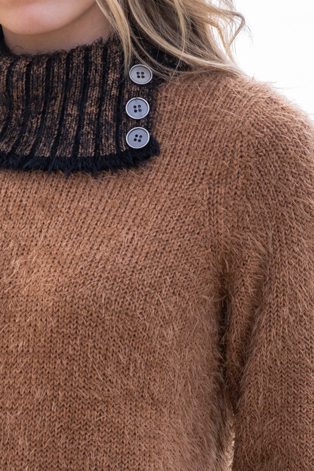 Close-up of a brown knitted sweater with button details