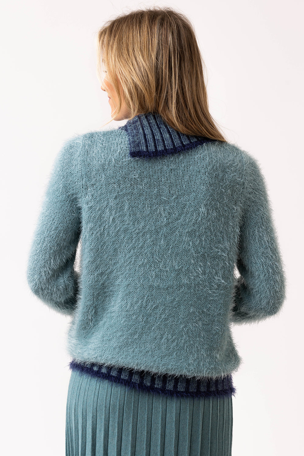 Woman wearing a light blue sweater with dark trim on a white background